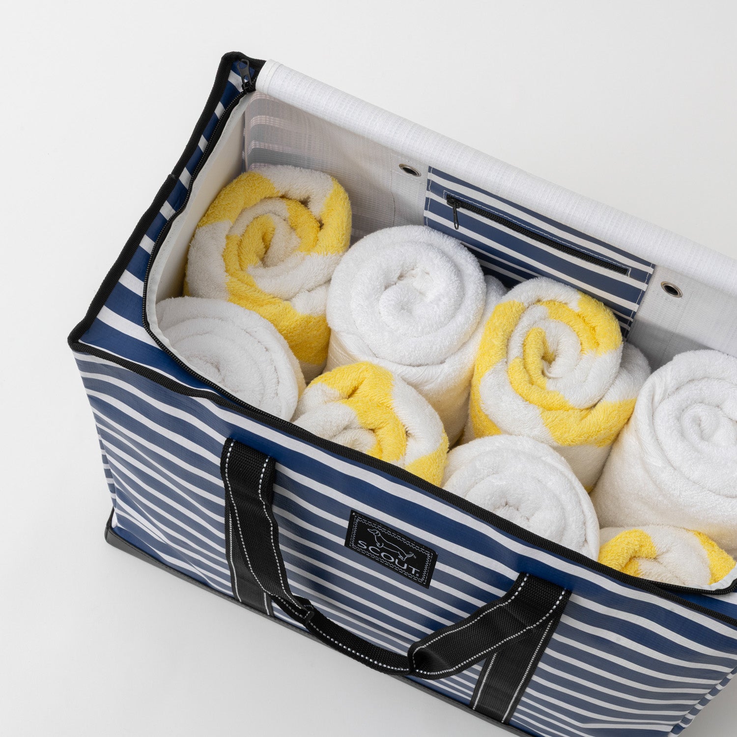 Striped storage bag filled with rolled-up towels on a white background