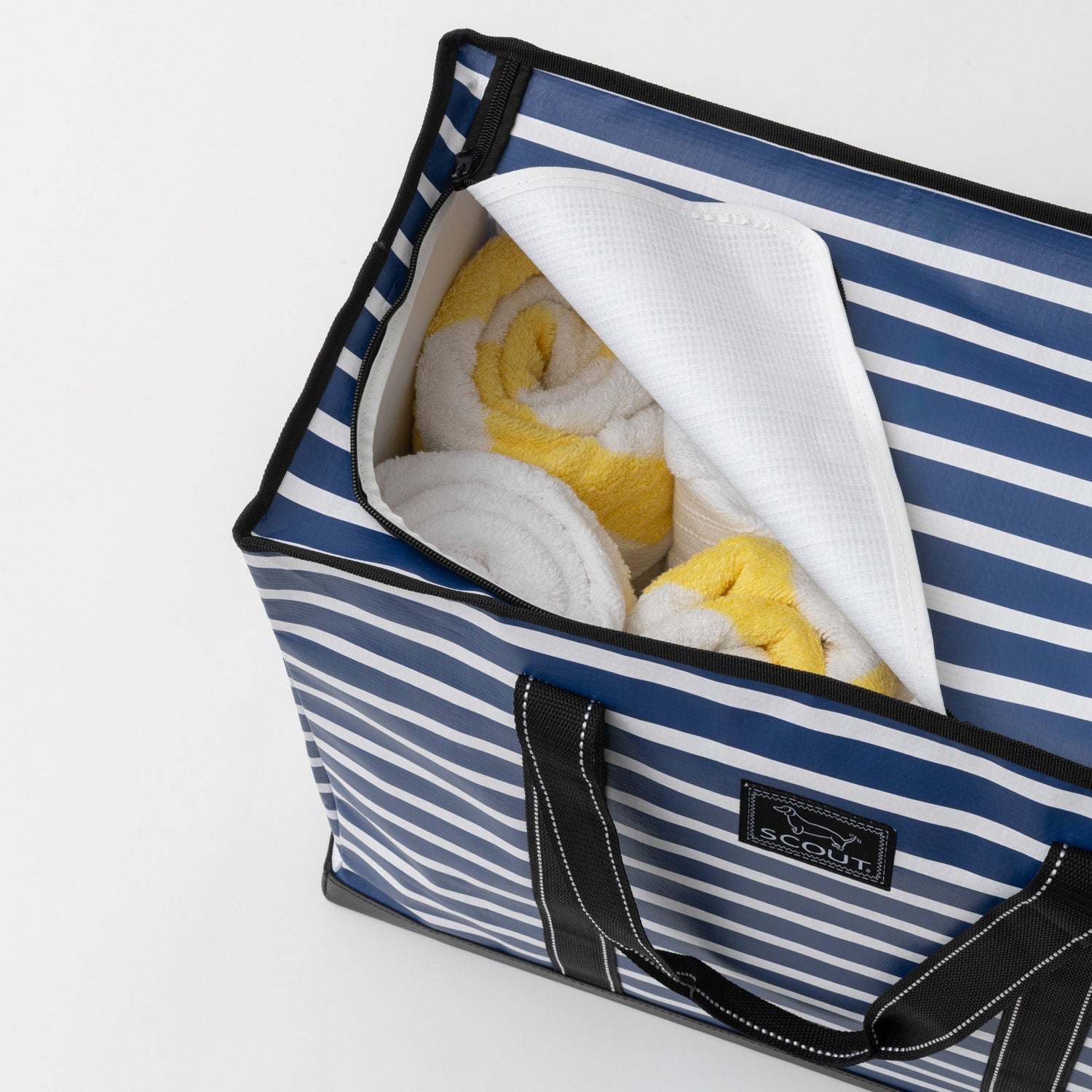 Blue and white striped bag with towels inside on a light gray background