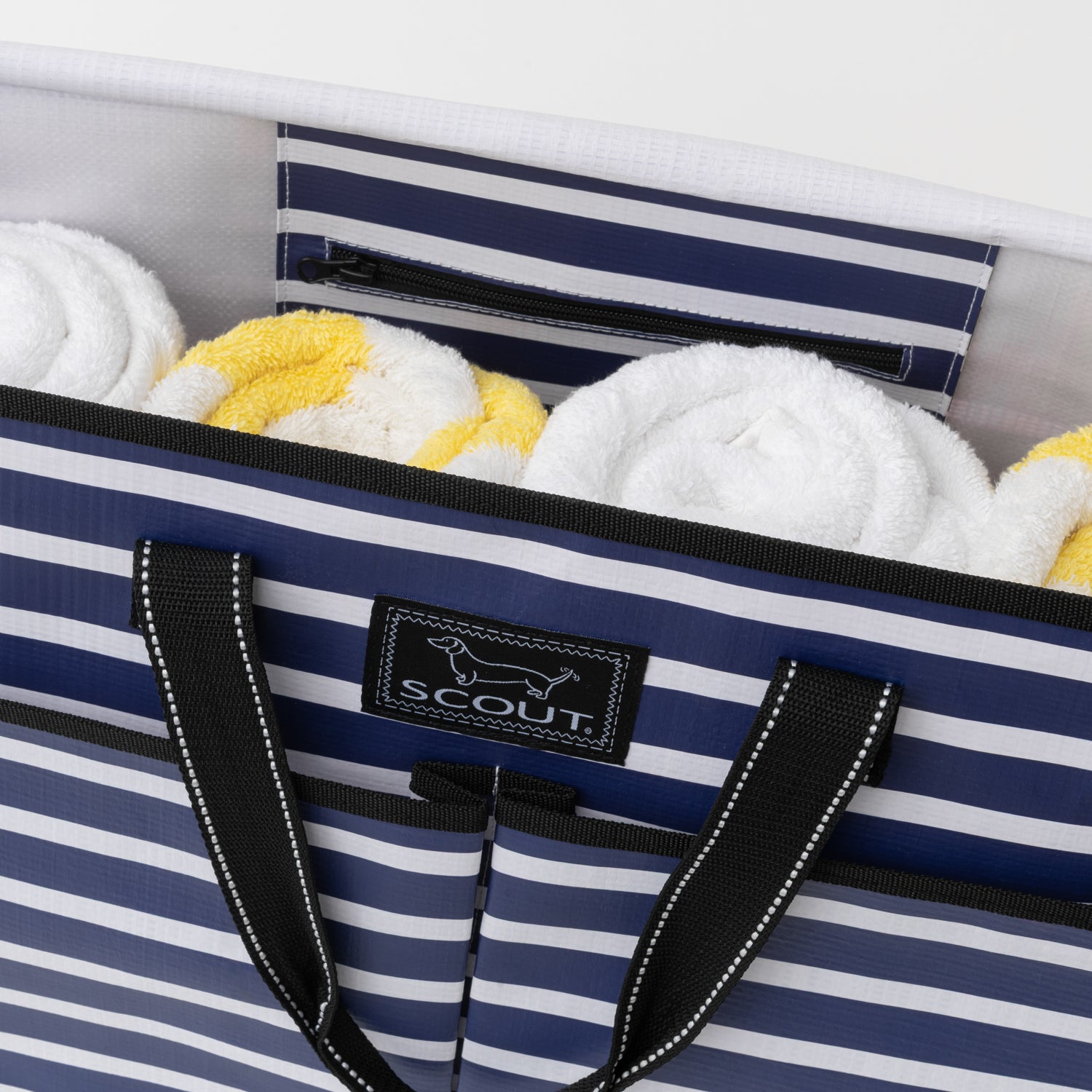 Striped tote bag with towels inside, featuring a visible brand logo.