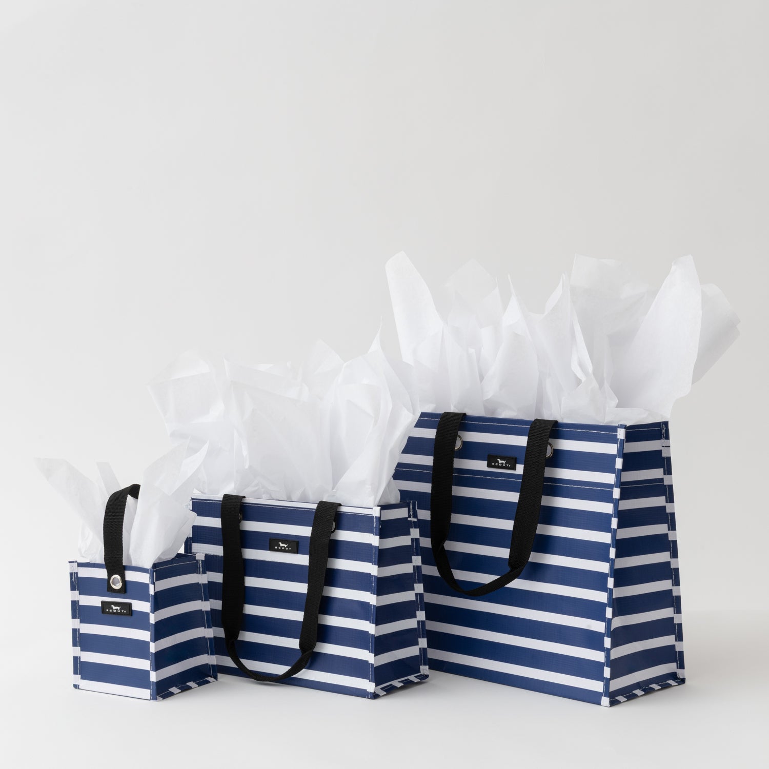 Set of three blue and white striped bags with black handles on a light gray background