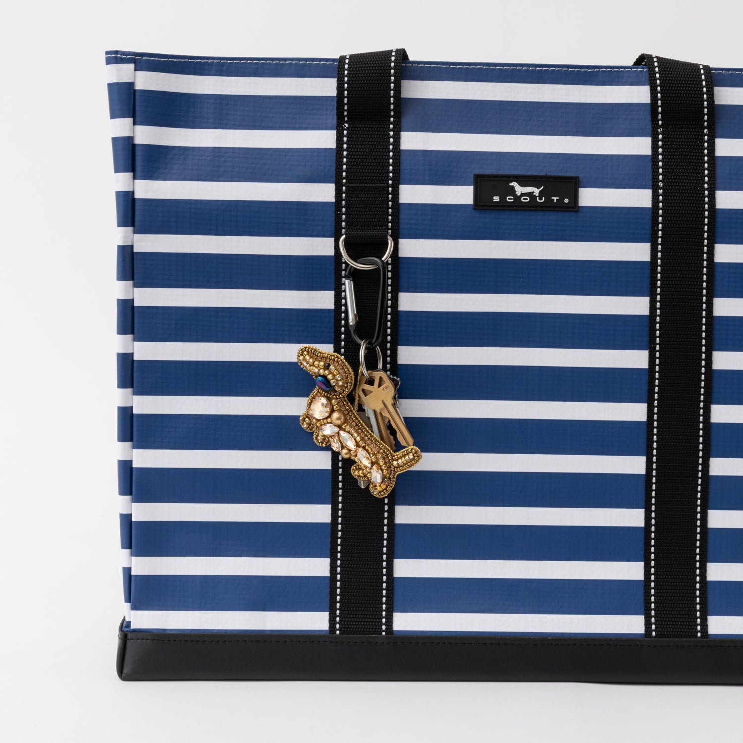 Blue and white striped bag with a gold keychain on a white background