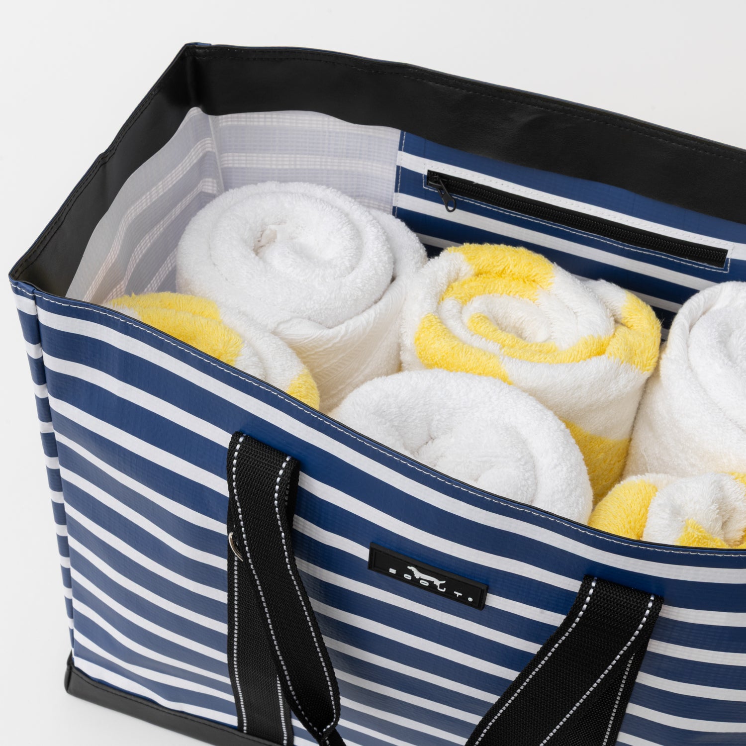 Blue and white striped storage bag with rolled towels inside on a light gray background