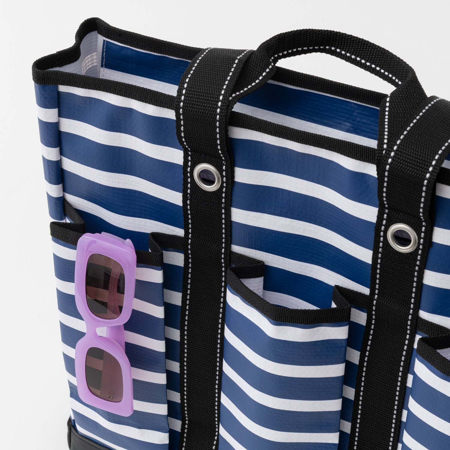 Blue and white striped bag with sunglasses pocket on a white background