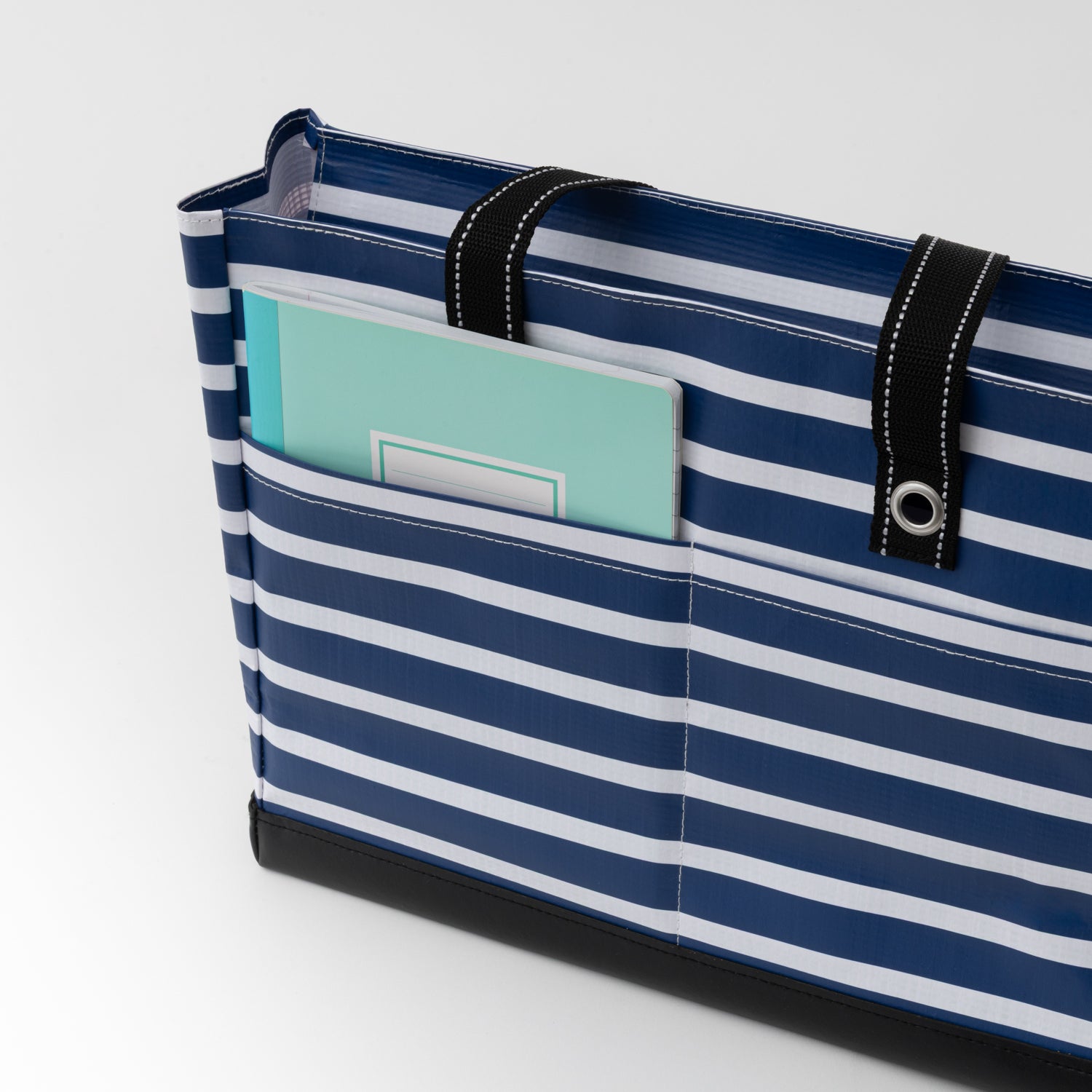 Navy and white striped bag with a green label on a light gray background