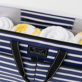 Striped tote bag with towels inside, featuring a visible brand logo.