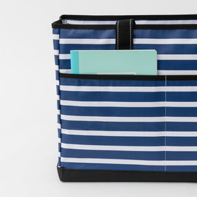 Blue and white striped tote bag with a teal book inside on a light gray background