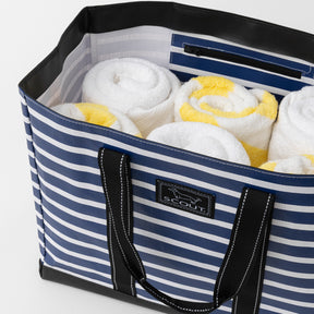 Blue and white striped tote bag with towels inside, featuring a Scout logo.