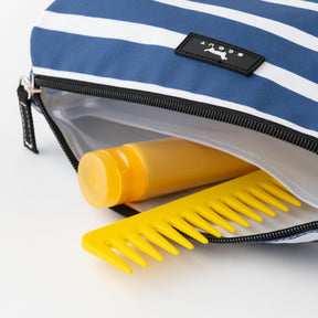 Yellow comb and bottle in a blue and white striped bag with a brand logo.