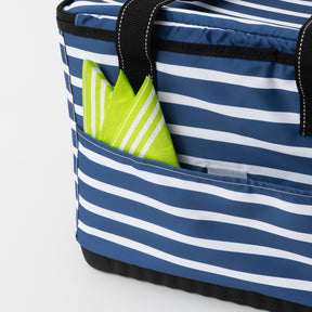 Blue and white striped tote bag with a green napkin peeking out on a light gray background